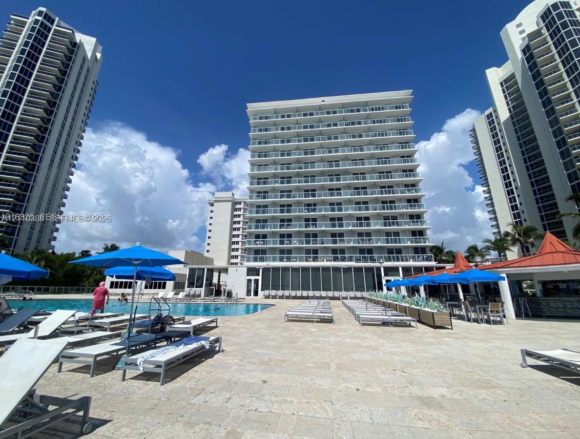 Swimming pool featuring a stone-tile deck and multi-story high-rise architecture with individual recessed balconies