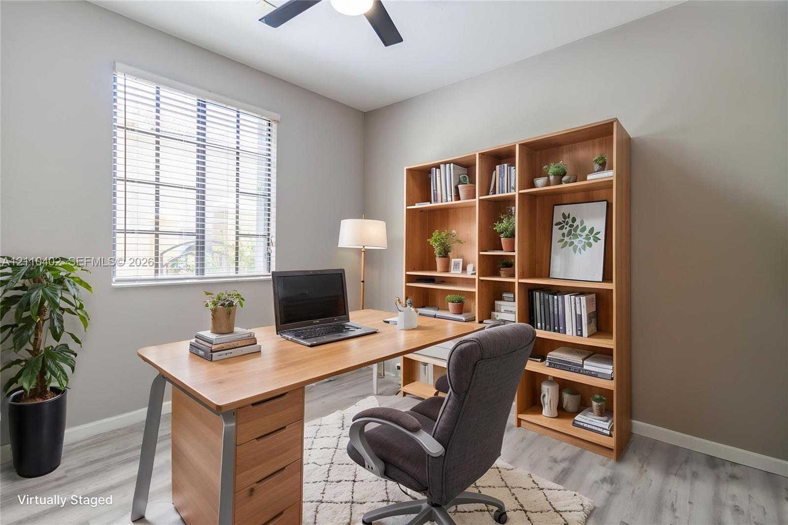 Room featuring neutral-toned walls, wood-finish flooring, a multi-pane window with horizontal blinds, and an integrated ceiling fan with light fixture