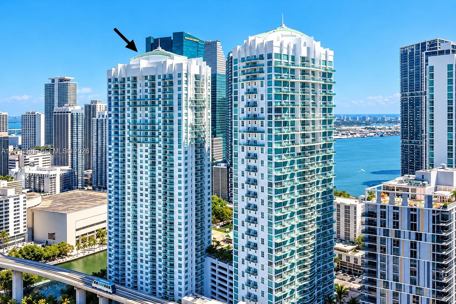 High-rise building featuring a white concrete facade, glass-enclosed balconies, and a dome-style architectural roof design High-rise building featuring a white concrete facade, glass-enclosed balconies, and a dome-style architectural roof design