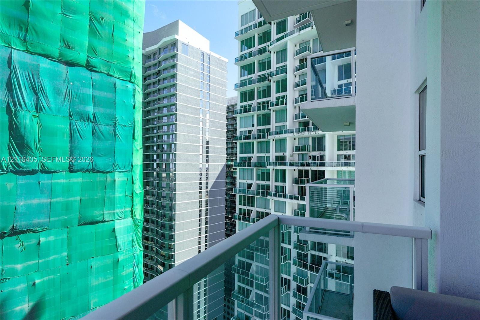 Private balcony featuring glass railings and white metal framing
