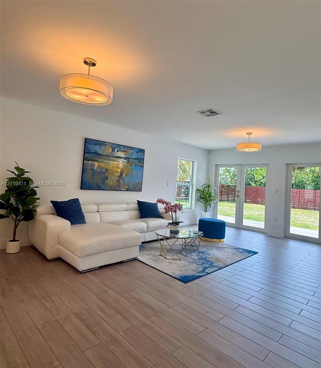 Wood-finish flooring, dual-pane windows, two sets of glass-paned doors, and drum-style ceiling light fixtures