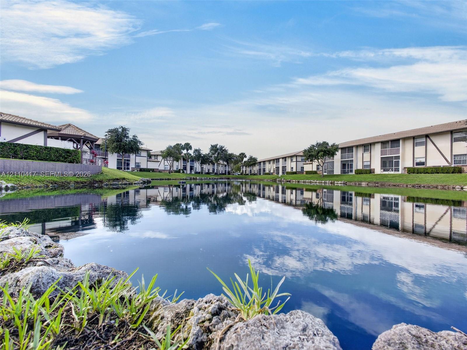 Serene waterfront setting with manicured grounds and mature landscaping