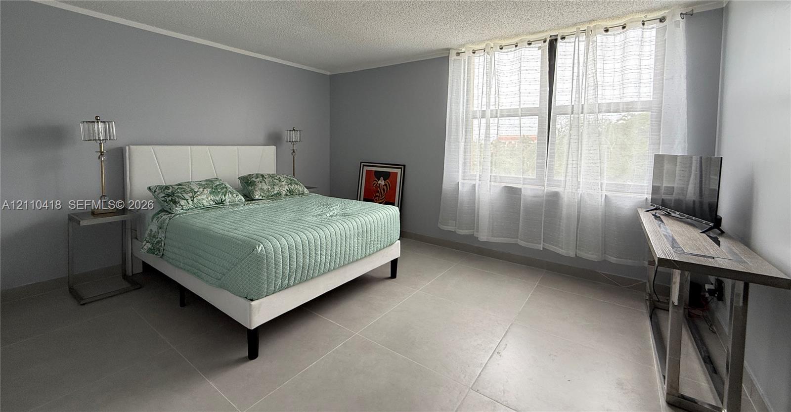 Large-format tile flooring, neutral wall tones, and expansive horizontal window featuring natural light