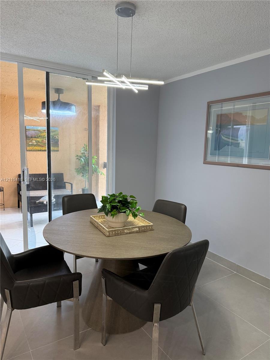 Contemporary linear LED pendant lighting, neutral-toned tile flooring, and sliding glass patio door