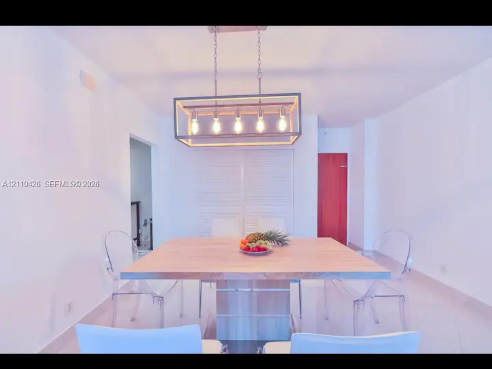 Rectangular linear chandelier with a metal frame, louvered closet doors, and smooth tile flooring Rectangular linear chandelier with a metal frame, louvered closet doors, and smooth tile flooring