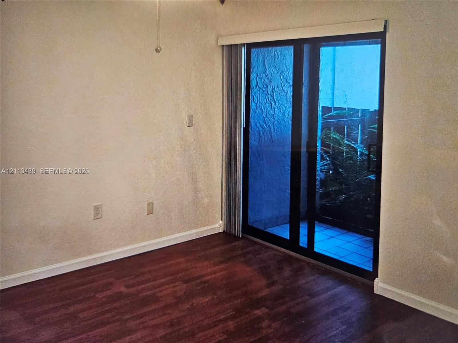 Wood-finish flooring, sliding glass door, and vertical blinds
