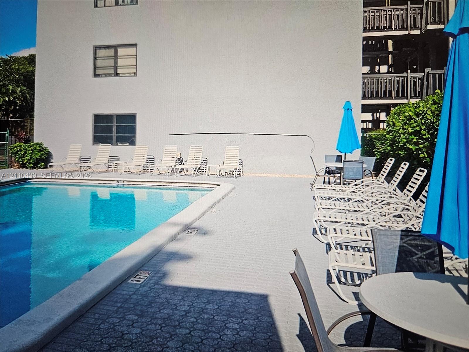 Swimming pool with a concrete pool deck and multi-story building exterior