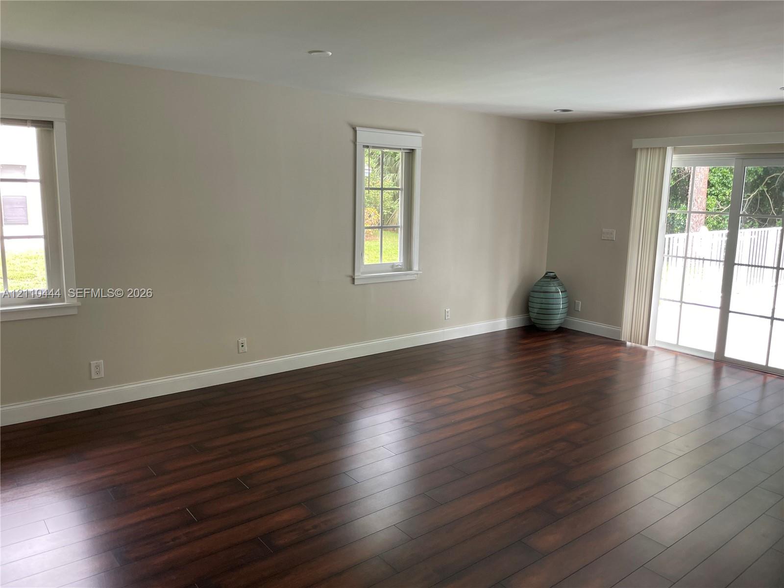 Interior space featuring wood-finish flooring, recessed lighting, double-hung windows with grid detailing, and glass sliding doors Interior space featuring wood-finish flooring, recessed lighting, double-hung windows with grid detailing, and glass sliding doors