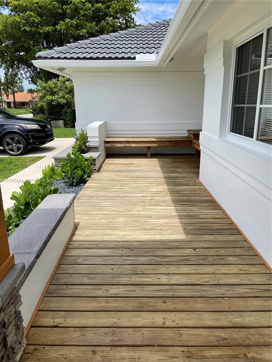 Exterior wood-plank decking featuring built-in bench seating, concrete block planters, and stacked stone accents