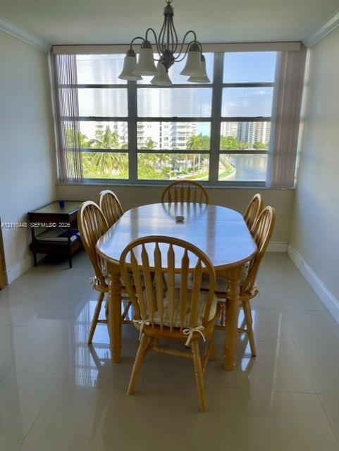 Large window featuring a metal frame, polished tile flooring, and an overhead multi-arm chandelier