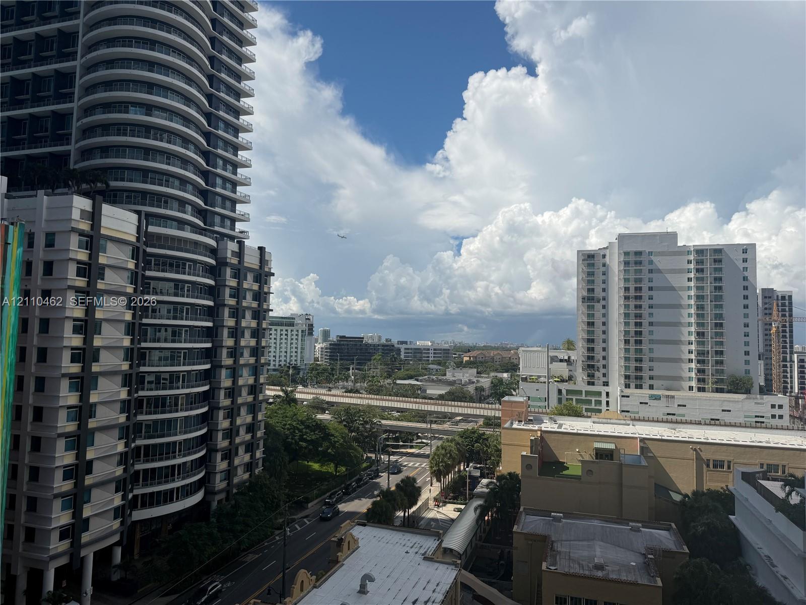 High-rise urban landscape featuring contemporary multi-story structures, glass-paneled architecture, and elevated transit infrastructure