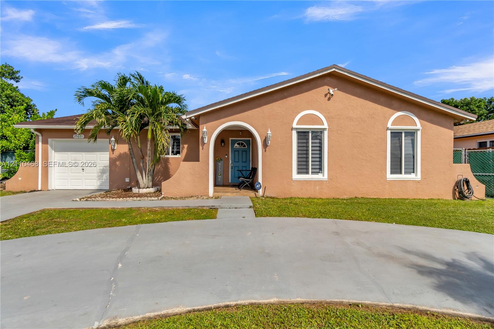 Stucco exterior featuring an arched entryway, single-car garage, concrete driveway, and window accents with arched detailing Stucco exterior featuring an arched entryway, single-car garage, concrete driveway, and window accents with arched detailing