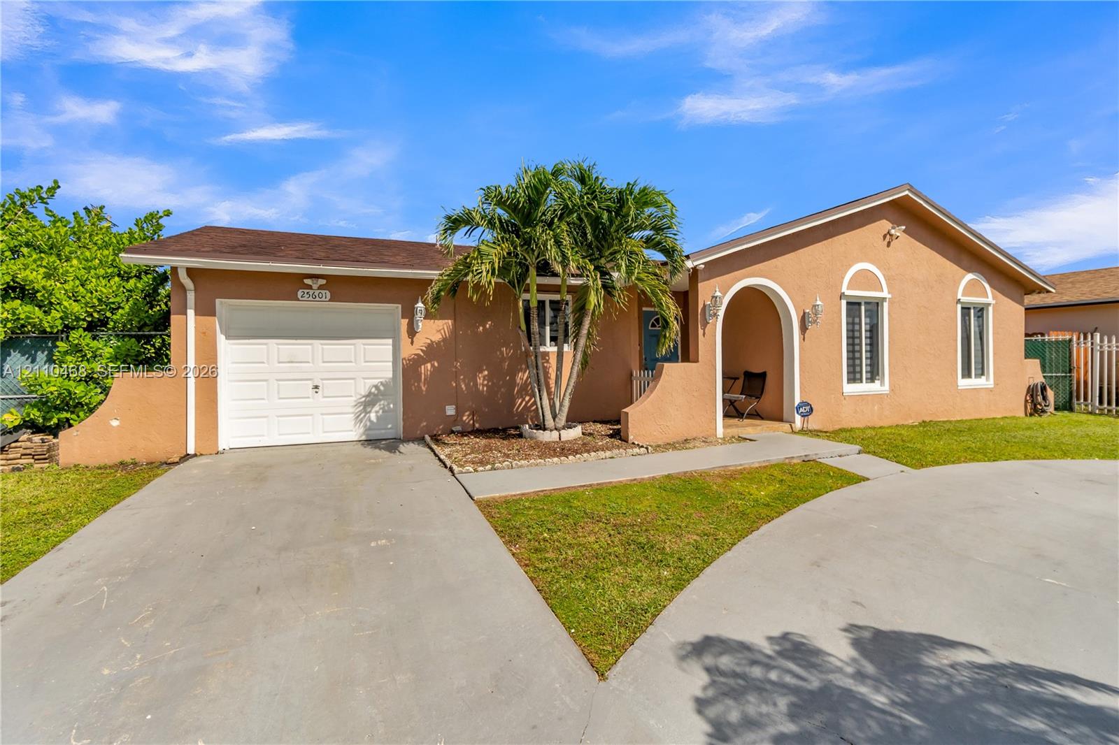 Single-story residence featuring a stucco exterior, arched entry, single-car garage, and concrete driveway