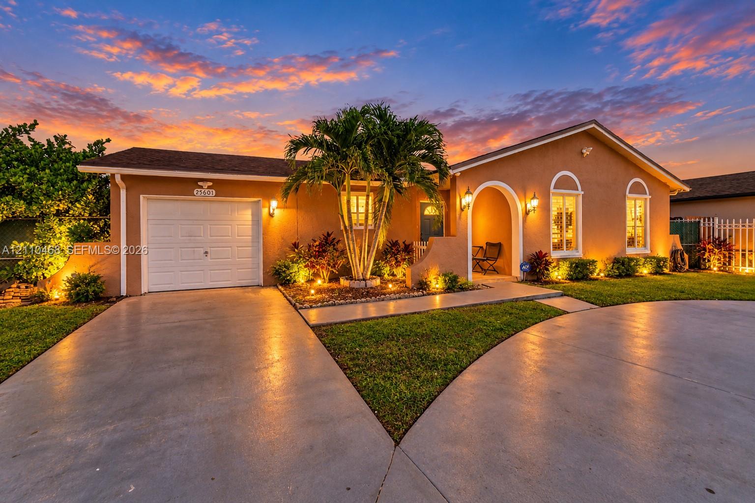 Single-story stucco exterior featuring an arched entryway, single-car garage, concrete driveway, and mature landscaping Single-story stucco exterior featuring an arched entryway, single-car garage, concrete driveway, and mature landscaping