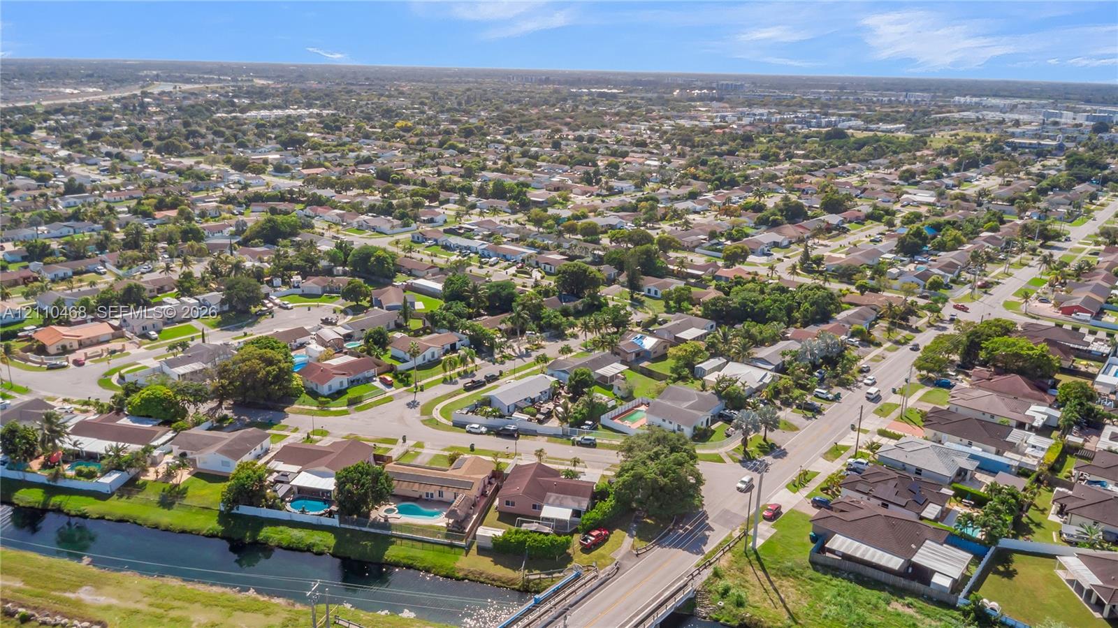 Aerial perspective of a suburban neighborhood featuring winding residential streets, established tree canopy, and waterfront lots
