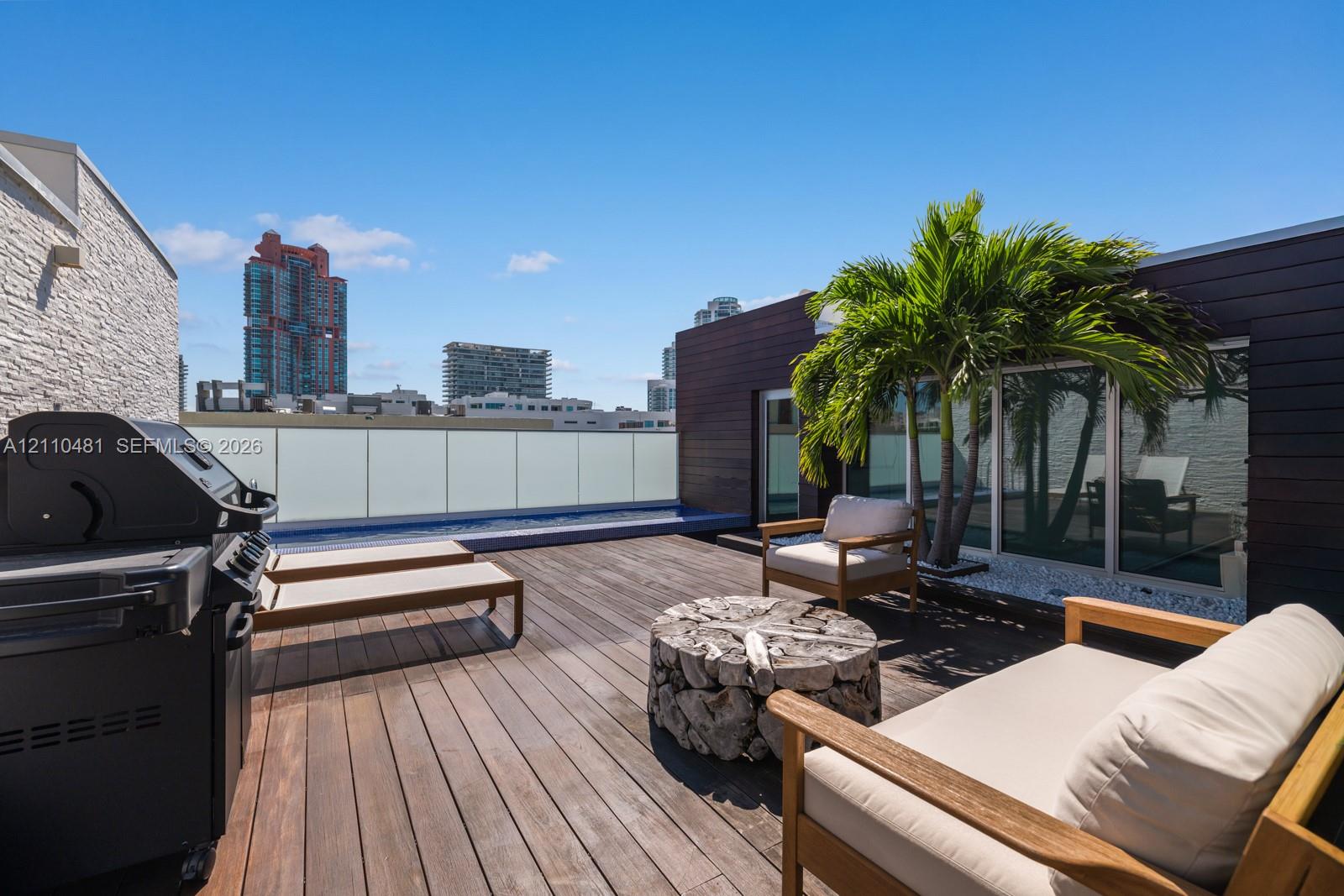 Rooftop terrace featuring wood decking, a built-in plunge pool, opaque glass railing, and dark horizontal wood-finish siding