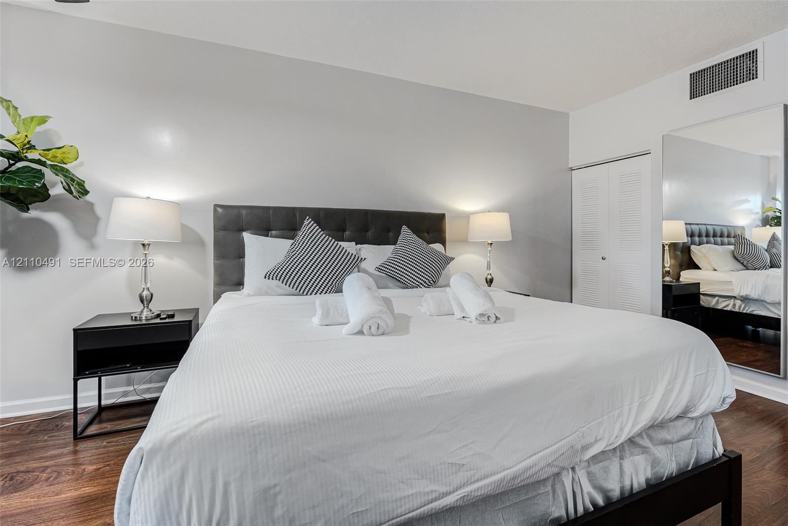 Spacious interior featuring wood-finish flooring, neutral wall paint, and a built-in closet with louvered doors