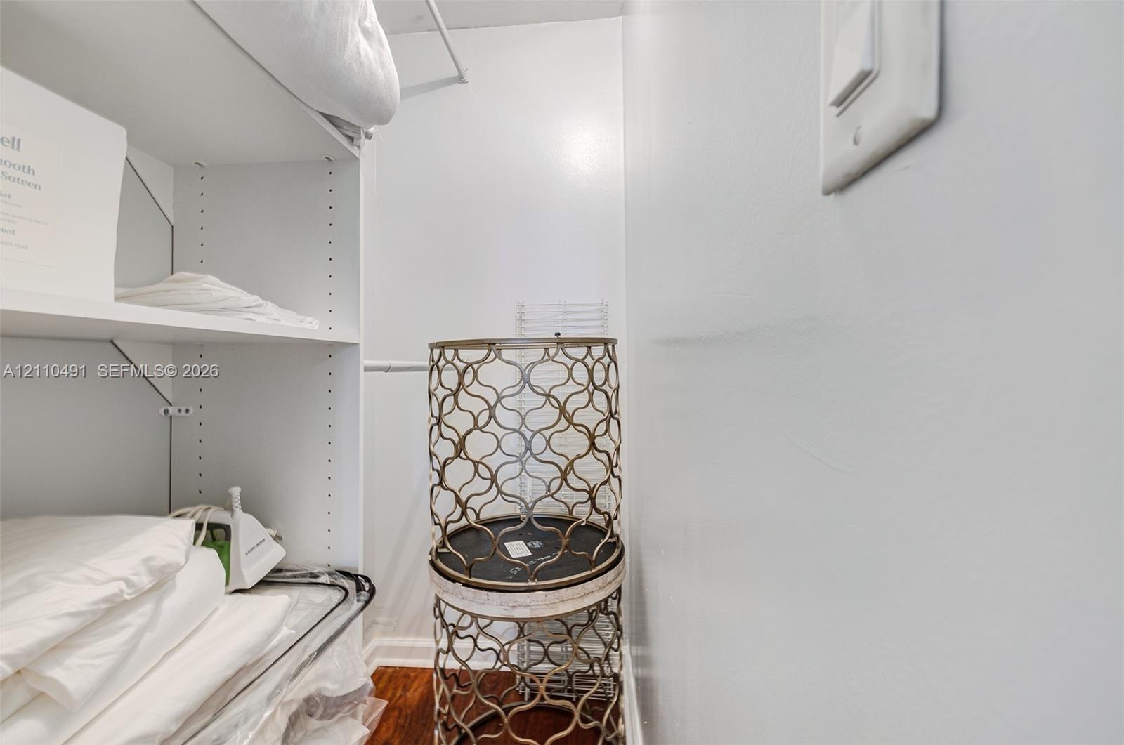 Storage area featuring adjustable shelving, integrated wire racking, and wood-finish flooring