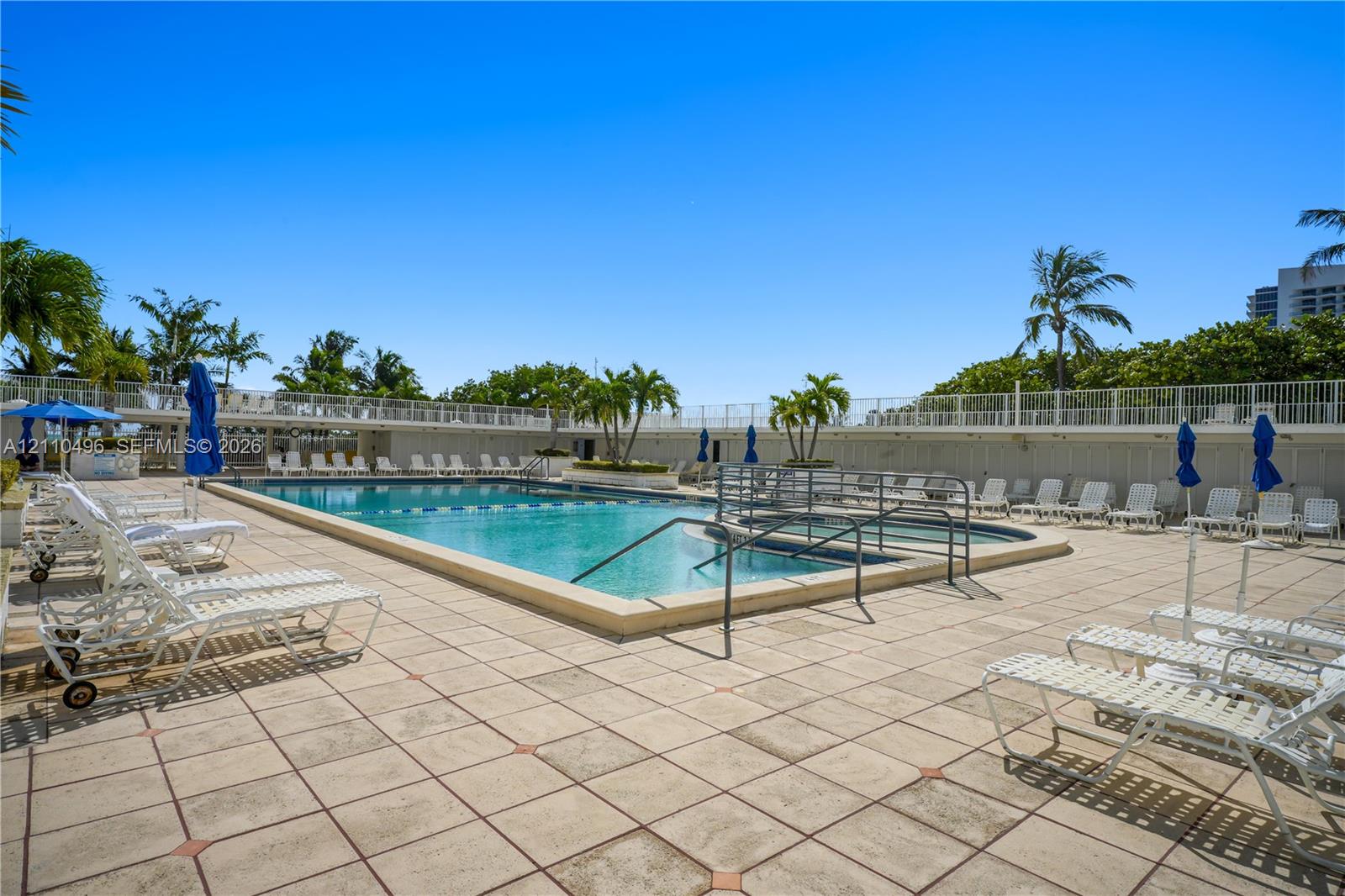 Swimming pool with an integrated spa, tiled pool deck, and perimeter fencing