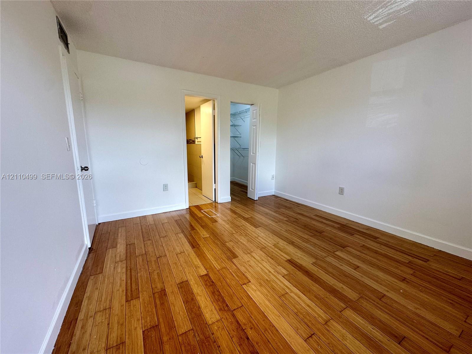 Wood-finish flooring, two interior doors, and a built-in reach-in closet