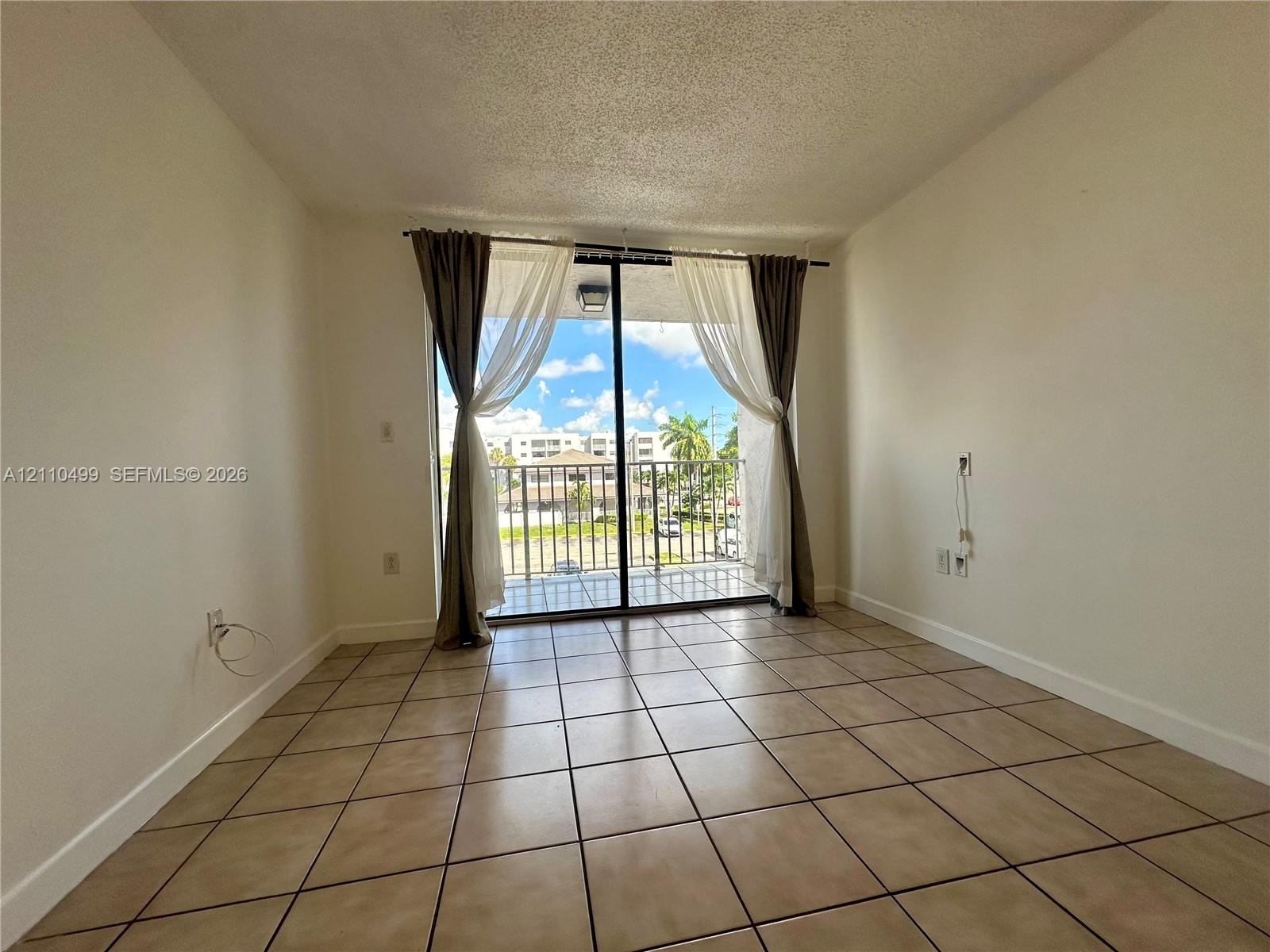 Ceramic tile flooring, sliding glass door, and private balcony with metal railing