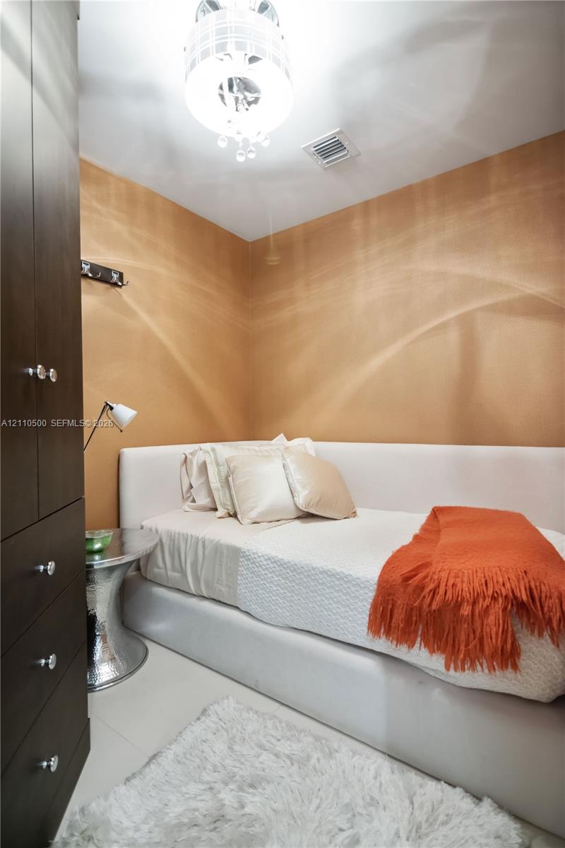 Floor-to-ceiling dark wood-finish cabinetry, textured amber wall treatment, and decorative ceiling pendant light