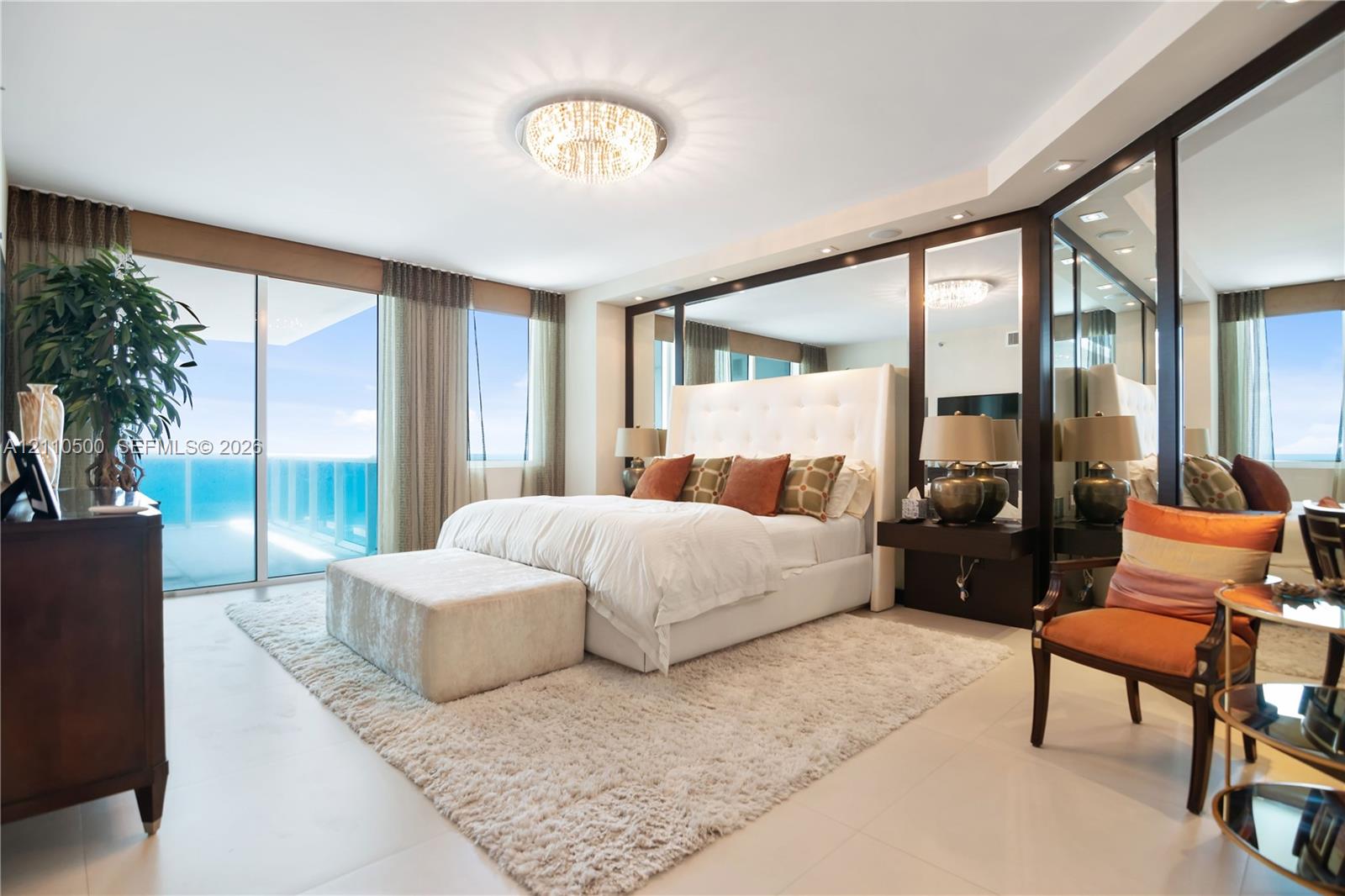 Full-height floor-to-ceiling glass sliding doors, expansive mirrored wall panels, polished tile flooring, recessed ceiling lighting, and integrated dark-tone floating nightstands