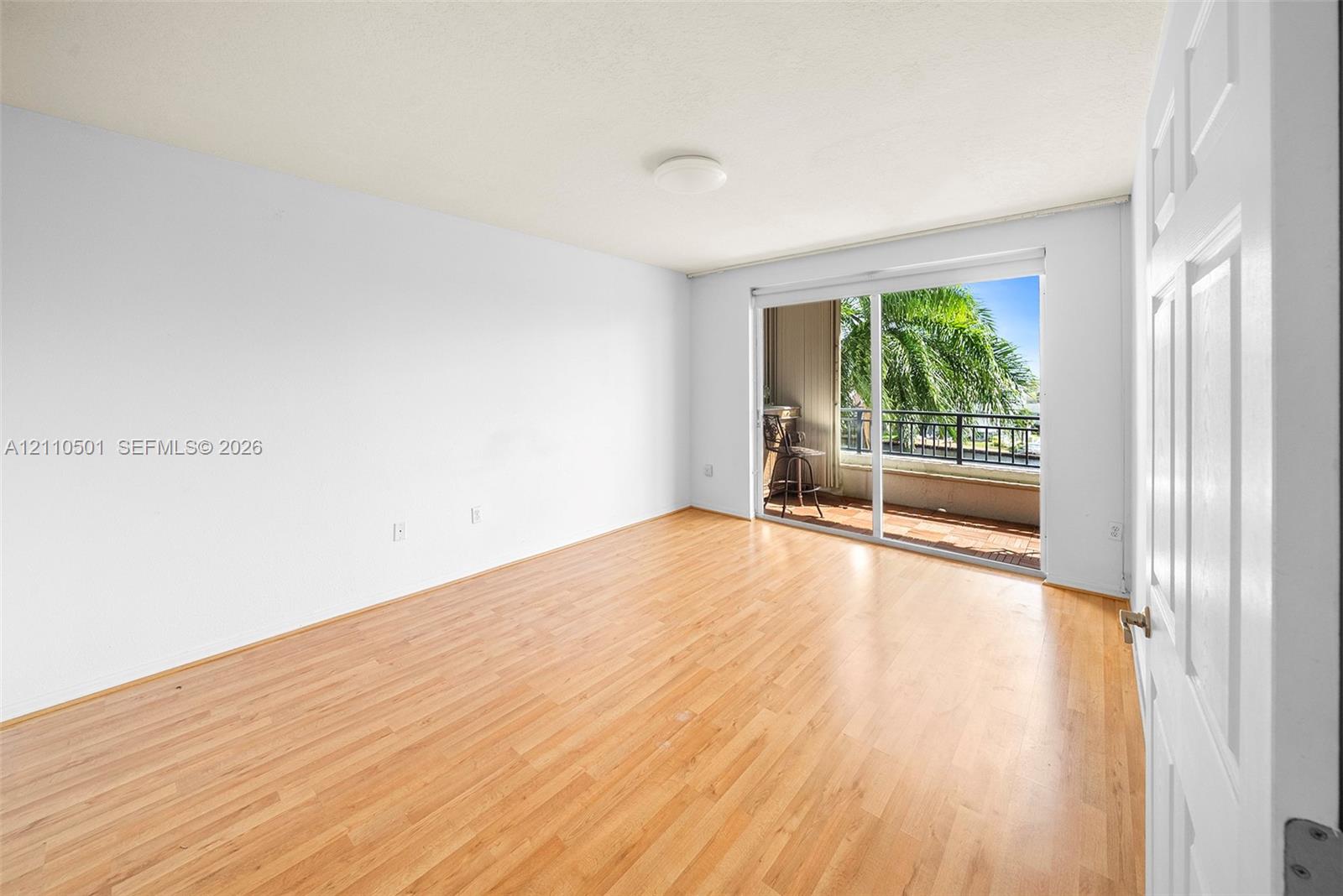 Primary Bedroom featuring wood-finish flooring, sliding glass doors, and a private balcony