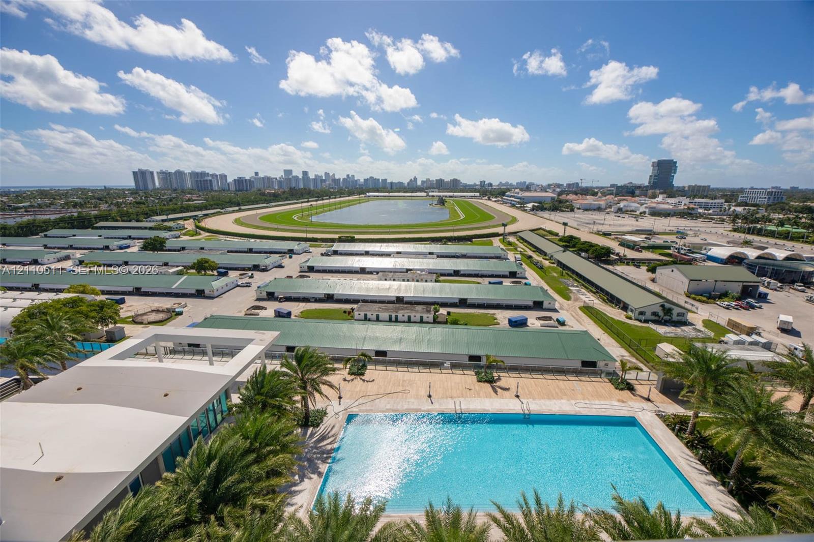 Rectangular swimming pool featuring stone-tile decking, surrounded by palm trees