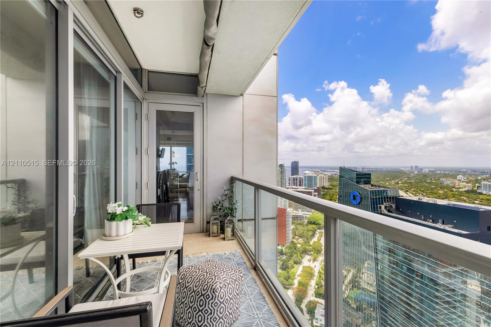 Private balcony featuring a glass panel railing, metal trim, and full-height sliding glass door entry