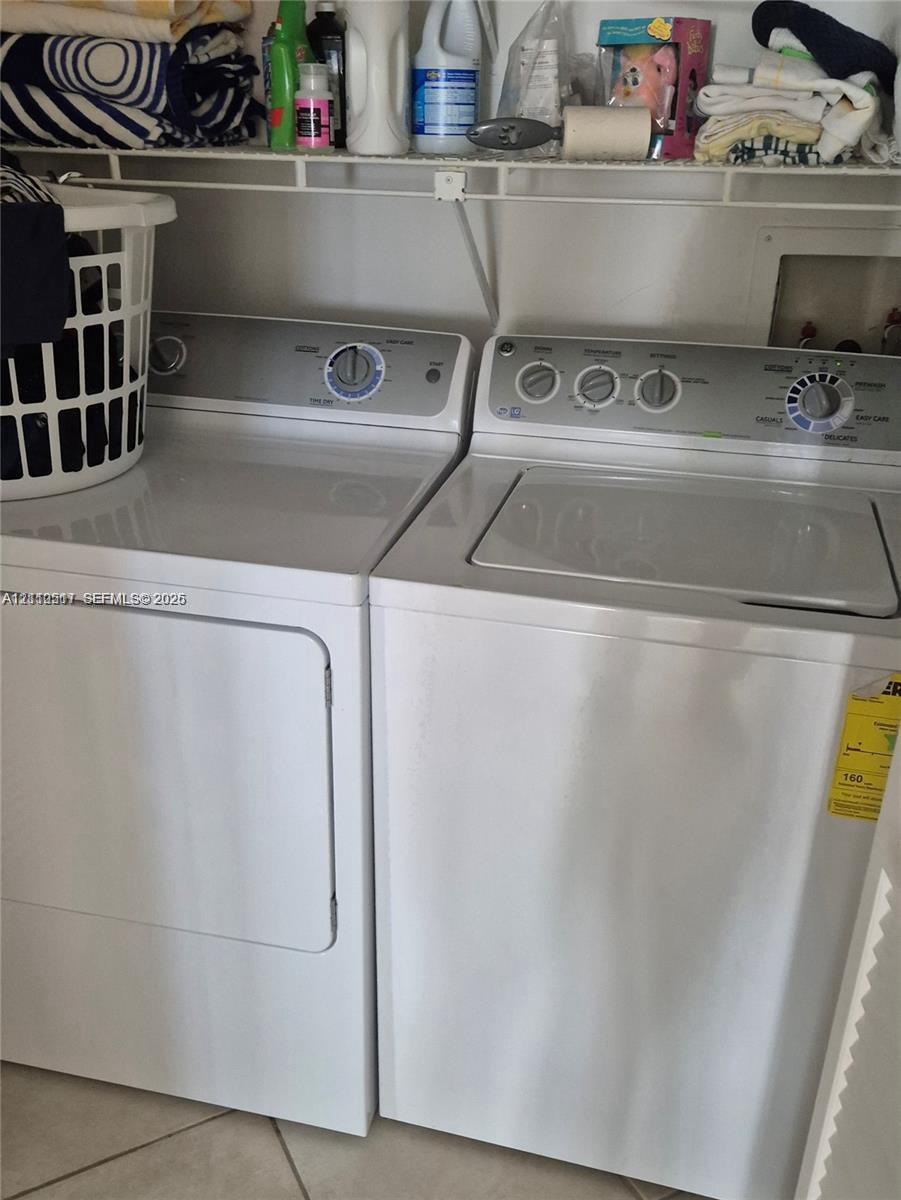 Laundry area featuring side-by-side appliances and wire shelving