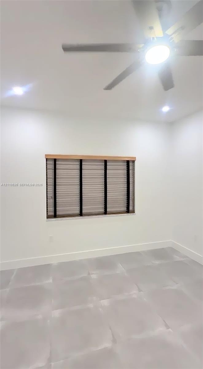 Interior room featuring large-format tile flooring, recessed lighting, and a multi-blade ceiling fan with an integrated light fixture