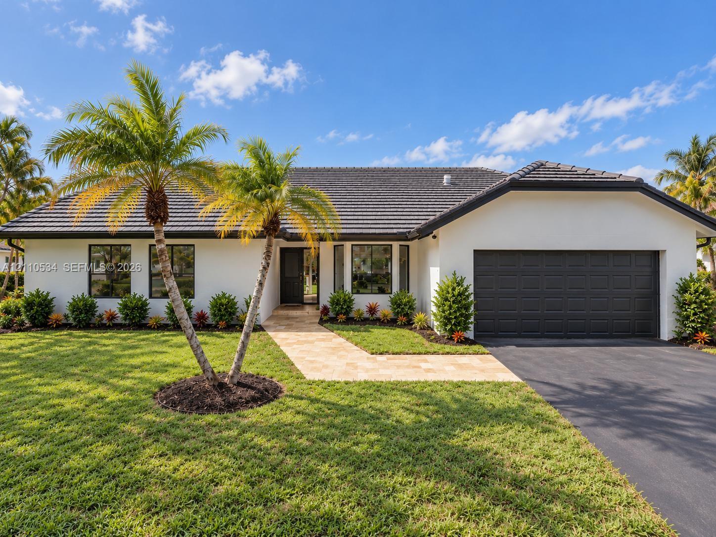 Single-story exterior featuring white stucco siding, a charcoal tile roof, a multi-paneled garage door, and a stone-paver walkway Single-story exterior featuring white stucco siding, a charcoal tile roof, a multi-paneled garage door, and a stone-paver walkway