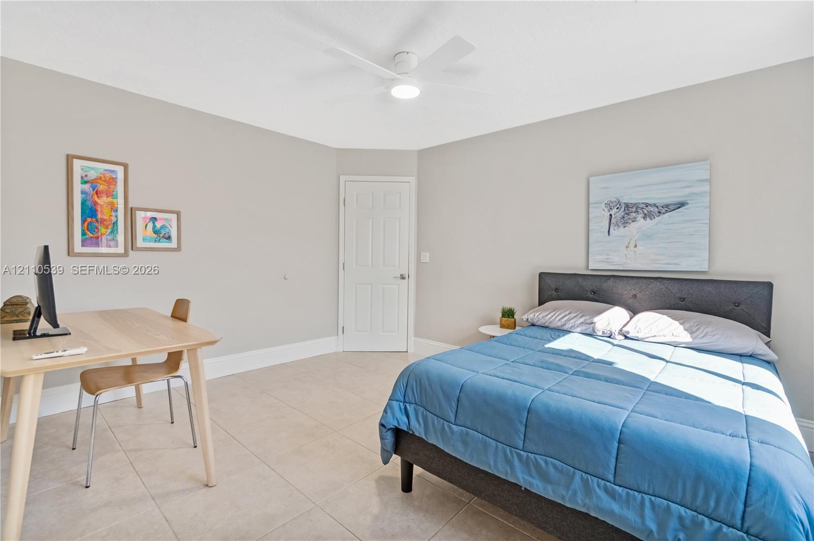 Neutral-toned walls, tile flooring, and a white ceiling fan with integrated lighting