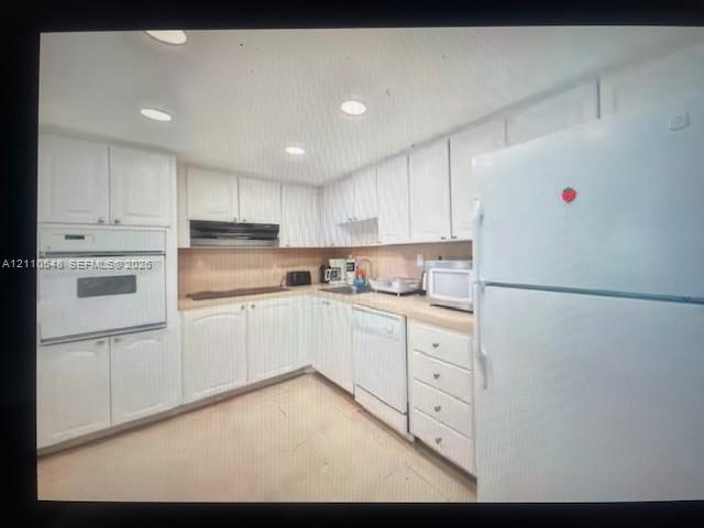 Kitchen featuring white cabinetry, integrated wall oven, dishwasher, neutral countertops, and recessed lighting