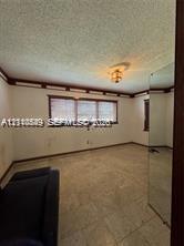Room featuring wood crown molding, a semi-flush mount ceiling light fixture, a triple-pane window, and mirrored closet doors