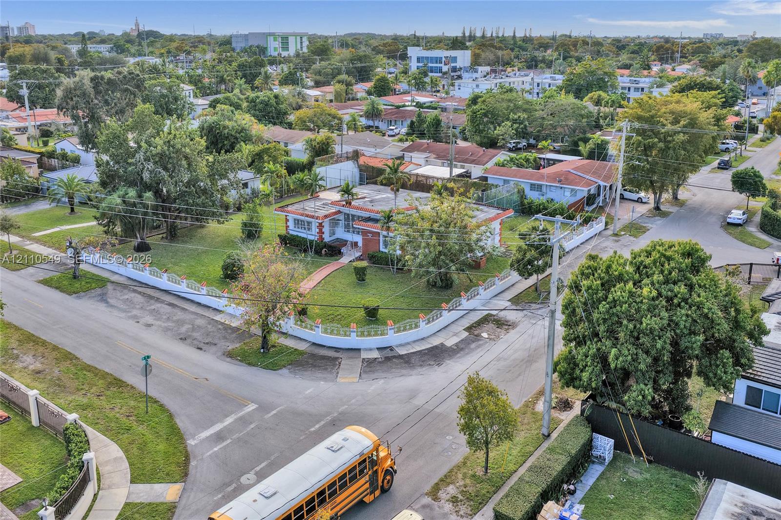 Corner lot property featuring a masonry perimeter wall, mature landscaping, and an expansive lawn
