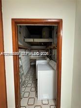Utility space featuring built-in wooden shelving, patterned flooring, and a door frame with wood trim