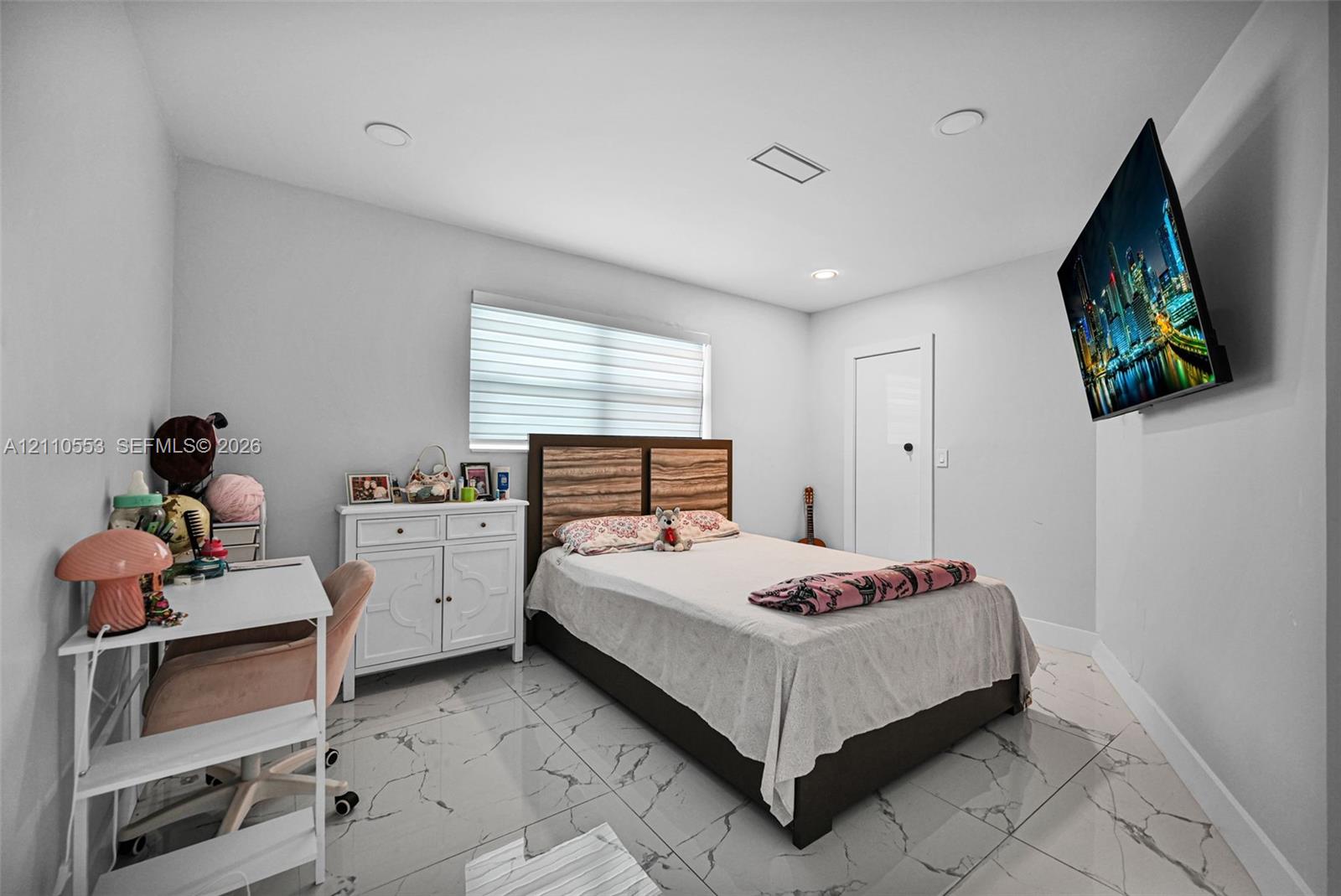Polished light-toned tile flooring with veining, recessed lighting, and a horizontal window treatment