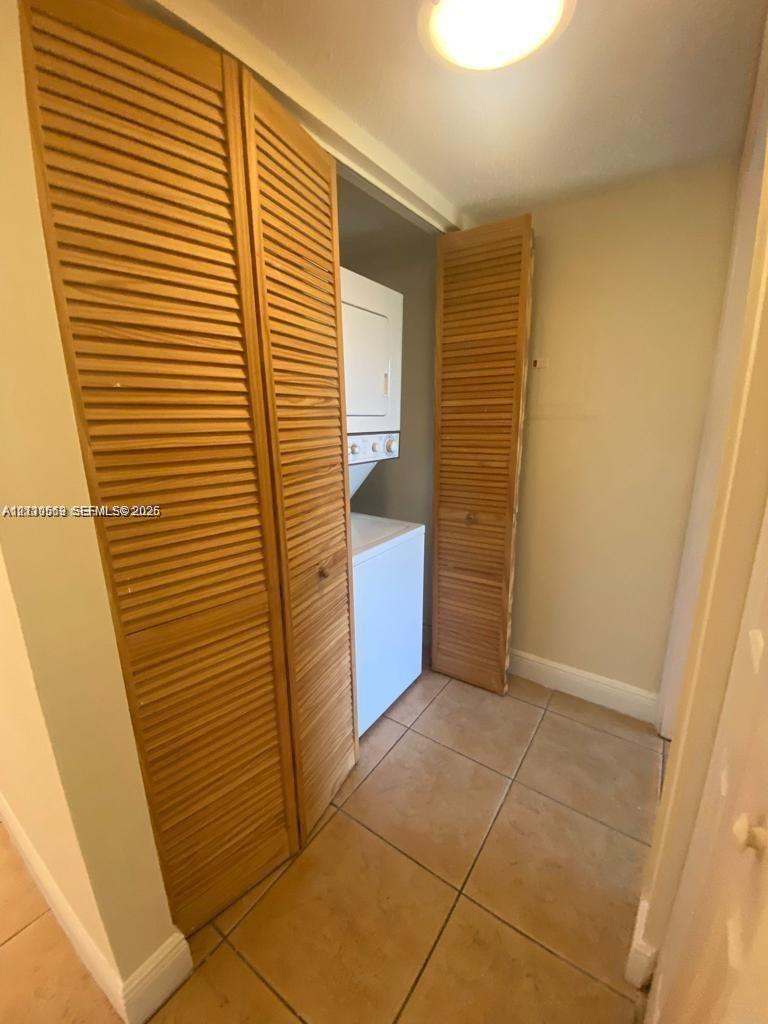 Laundry space featuring tile flooring and bi-fold wood louvred closet doors Laundry space featuring tile flooring and bi-fold wood louvred closet doors