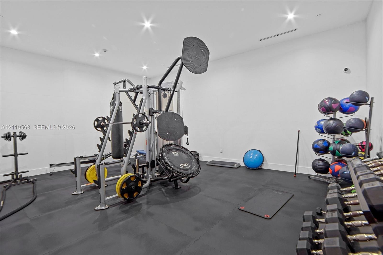 Spacious room featuring resilient rubber flooring and recessed ceiling lighting