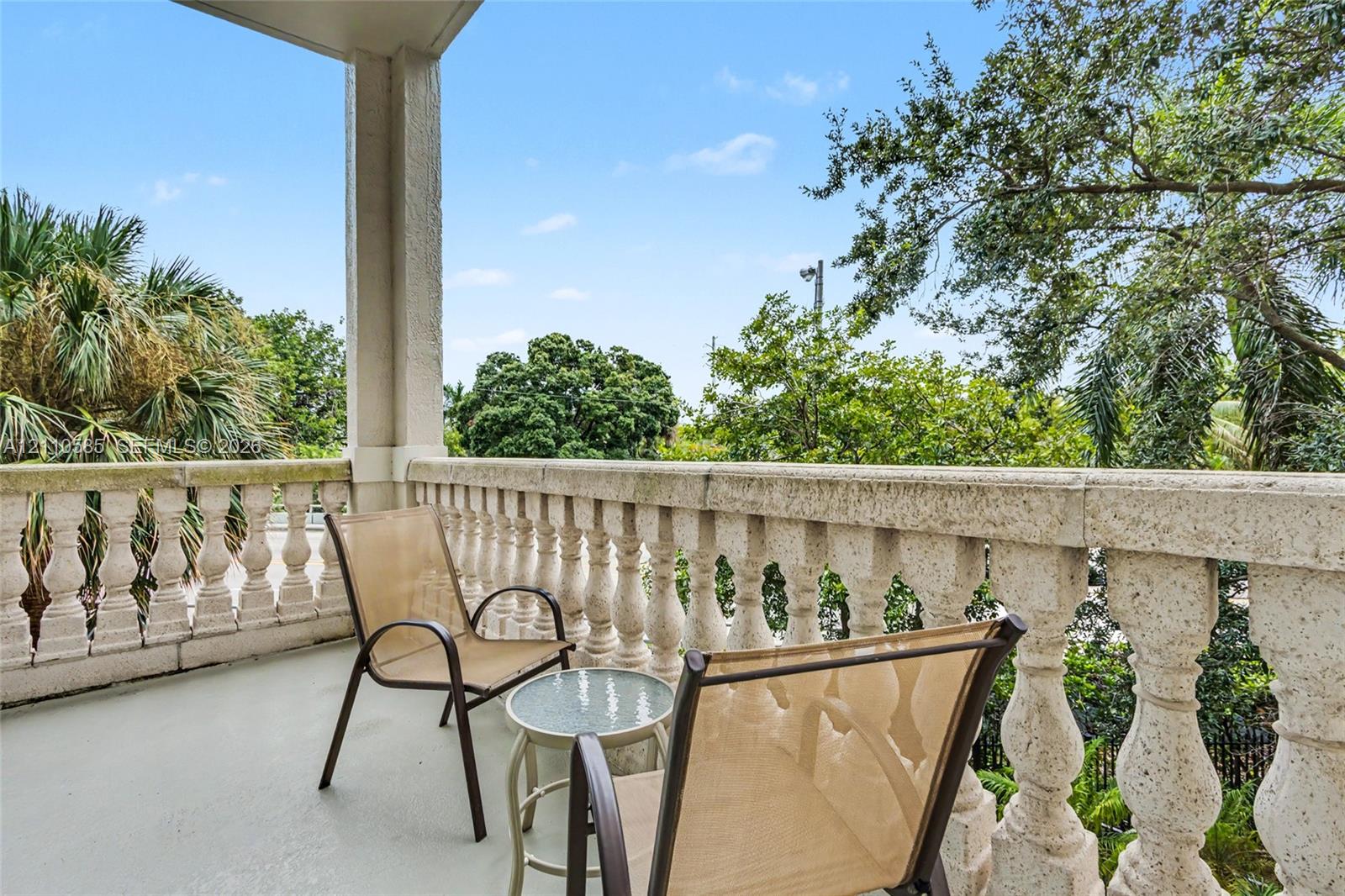 Covered balcony featuring a textured stone-finish balustrade, support column, and concrete flooring