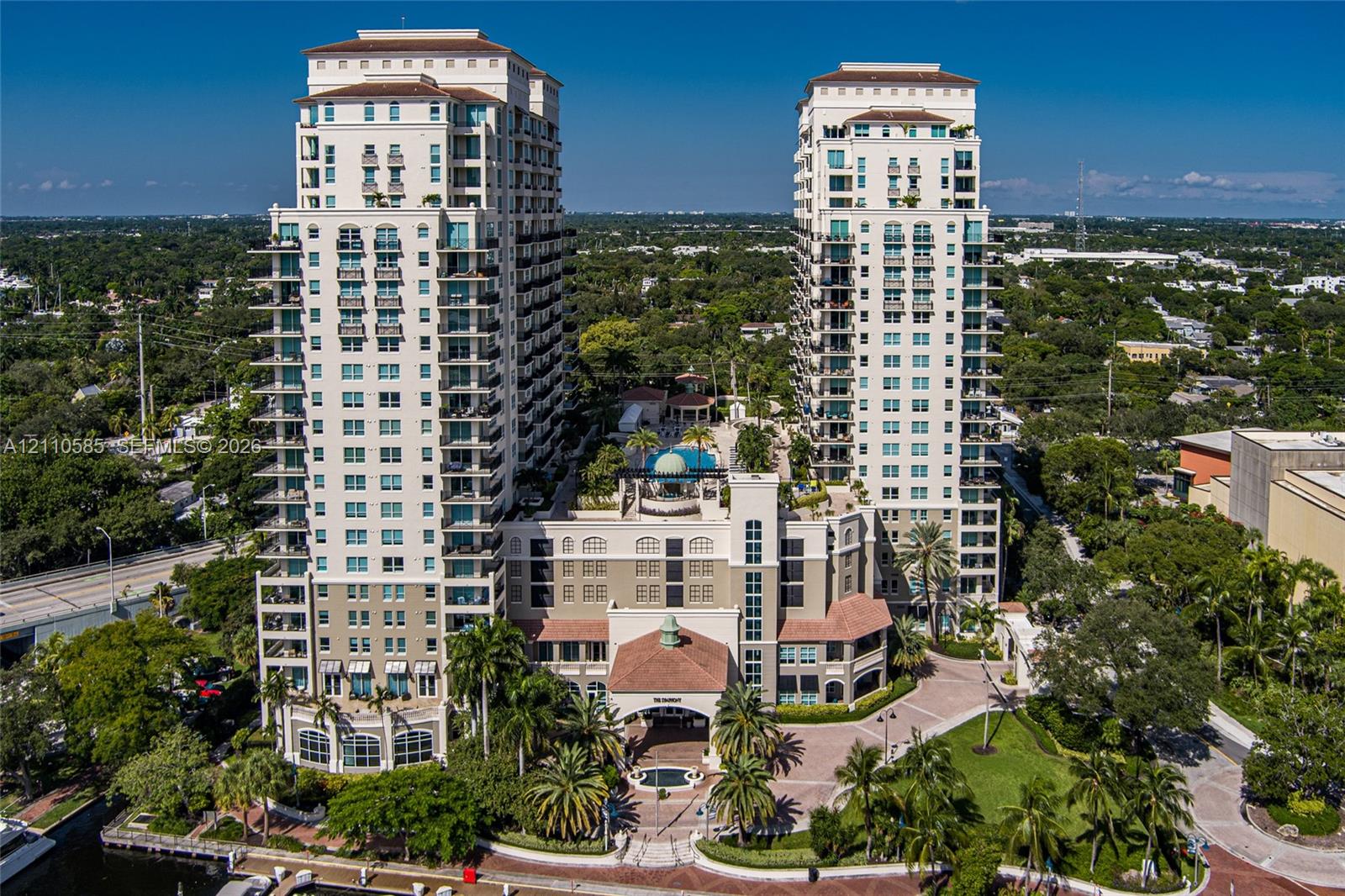 Symphony: High-rise residential towers featuring deep-water dockage, brick-paved walkways, and established tropical landscaping situated along a waterway