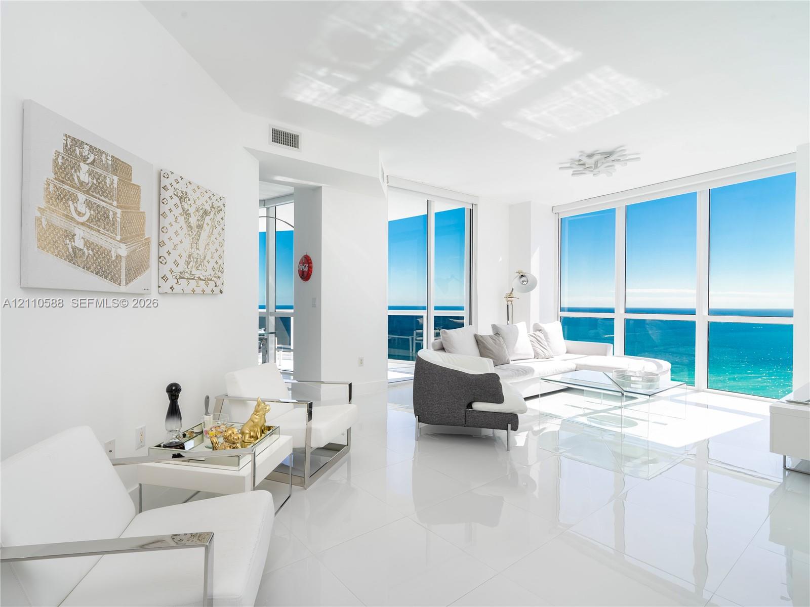 Floor-to-ceiling glass windows, polished tile flooring, and integrated recessed lighting