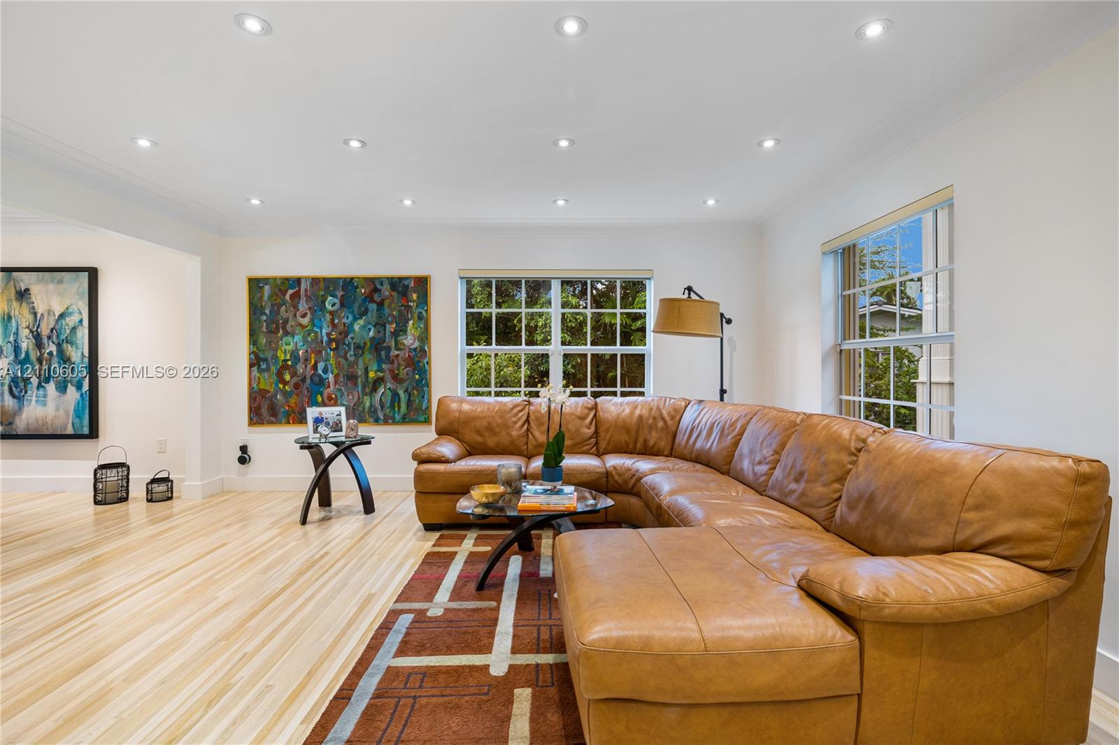 Light-toned wood-finish flooring, recessed lighting, and grid-pattern windows