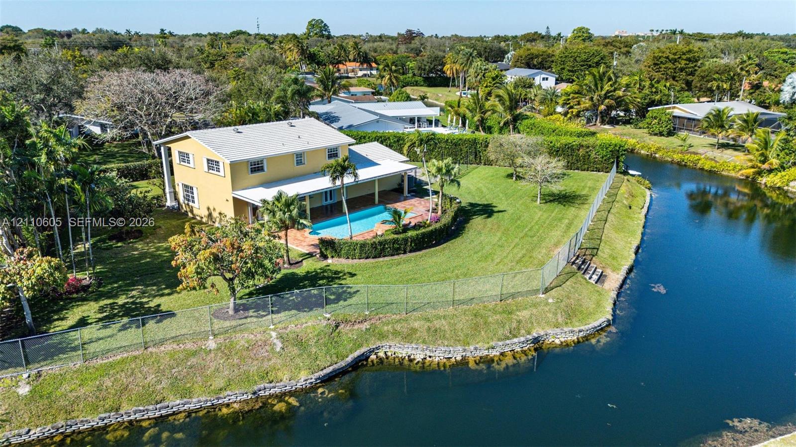 Two-story residence featuring a private in-ground swimming pool, covered patio, expansive lawn, and direct water frontage Two-story residence featuring a private in-ground swimming pool, covered patio, expansive lawn, and direct water frontage