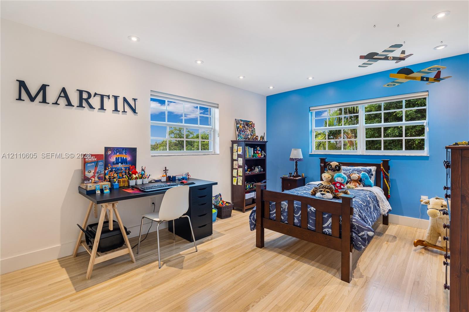 Room featuring wood-finish flooring, recessed lighting, and multiple windows with muntin detailing