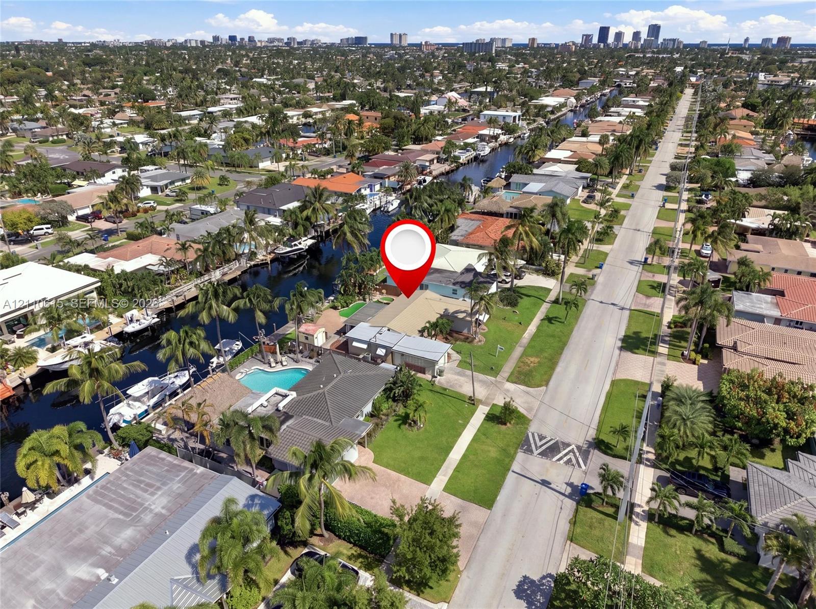 Aerial perspective of waterfront property featuring a private swimming pool, concrete bulkhead, and direct waterway access