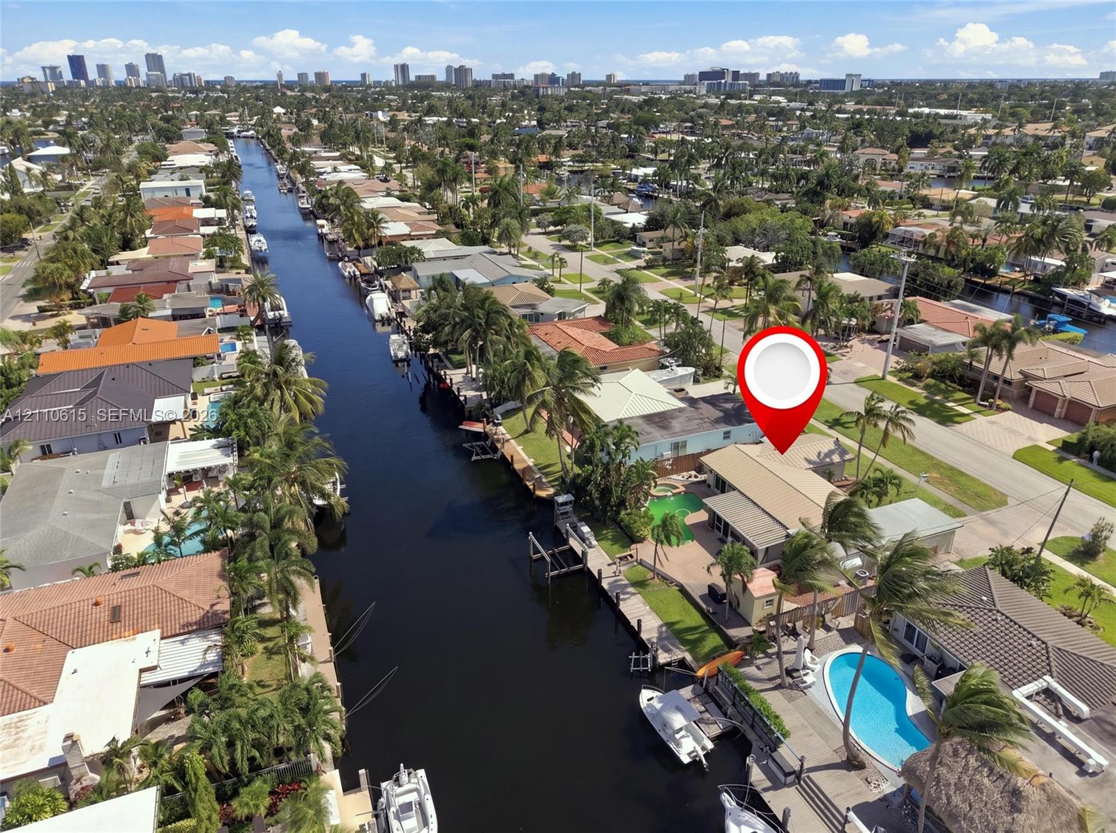 Waterfront property featuring a private boat dock, in-ground swimming pool, concrete patio, and direct canal access