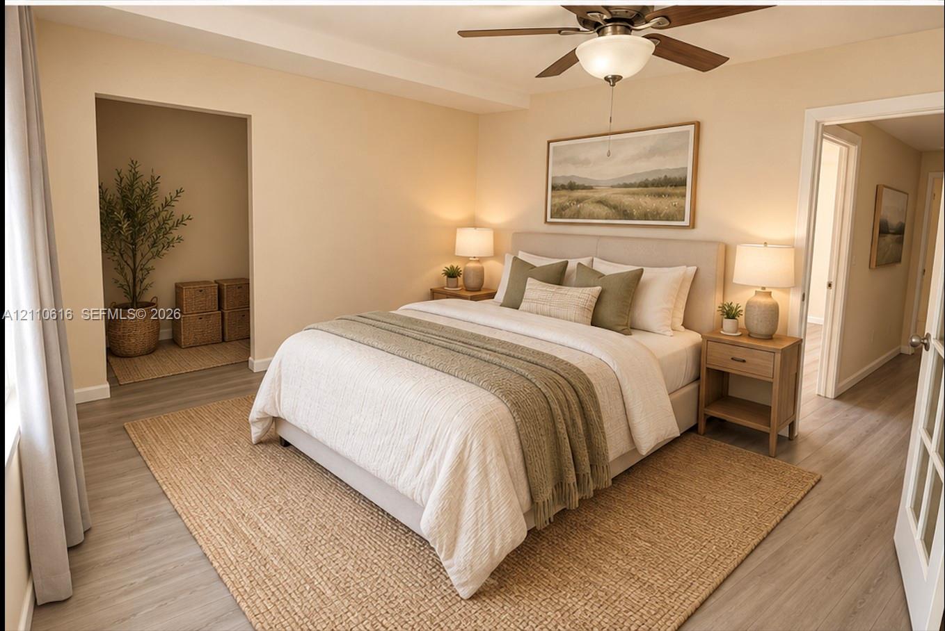 Neutral-toned bedroom featuring wood-finish flooring, a recessed nook, and a ceiling fan with integrated lighting Neutral-toned bedroom featuring wood-finish flooring, a recessed nook, and a ceiling fan with integrated lighting